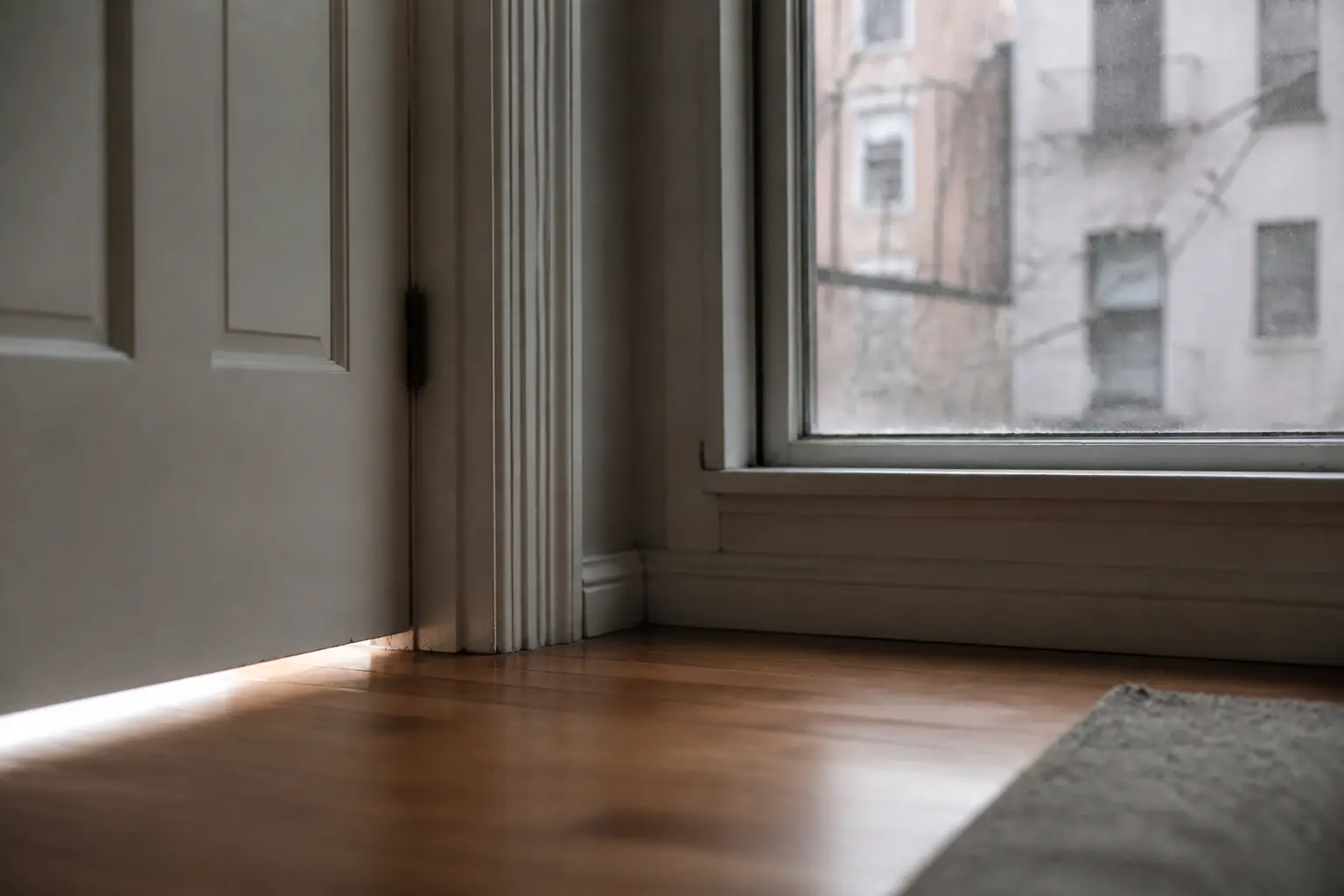 Insonoriser une pièce : porte entrouverte et fenêtre simple vitrage laissant passer le bruit.